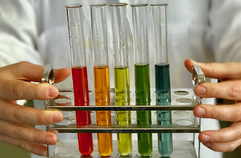 Laboration med vätska i olika färger i provrör.